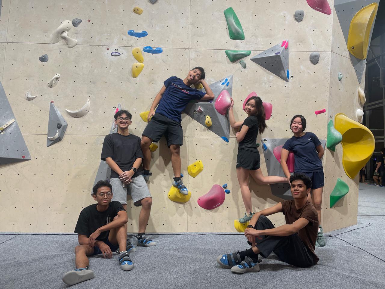 Ivan and friends posing on the wall at an indoor bouldering gym